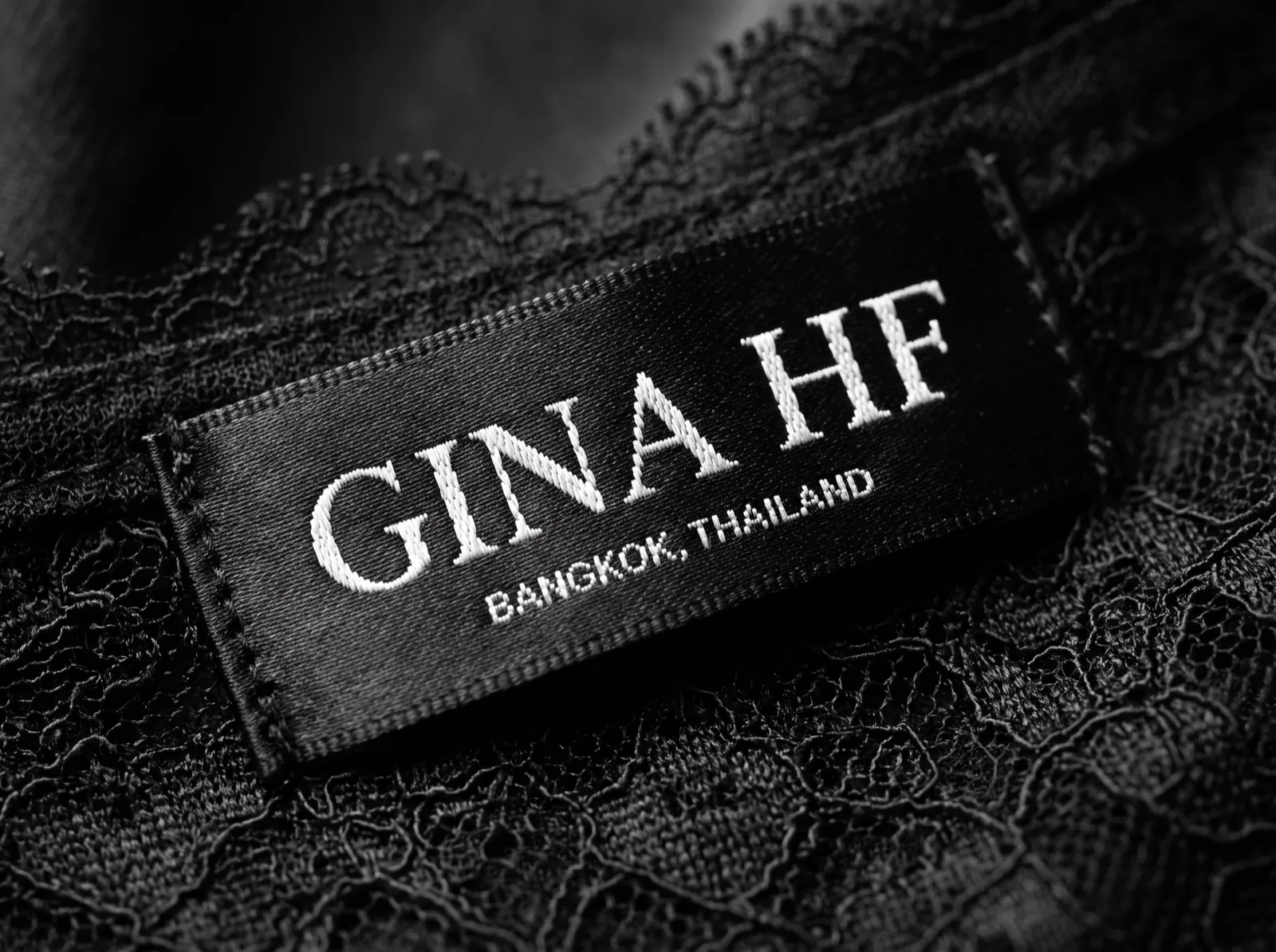 The woven GINA HF label on black lace — Nocturne editorial